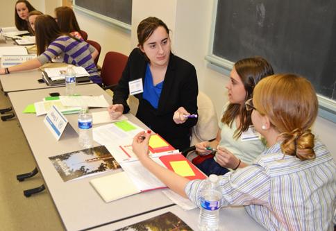 Three women sit at a table and confer.